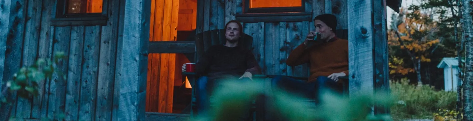 two people sitting in front of cabin